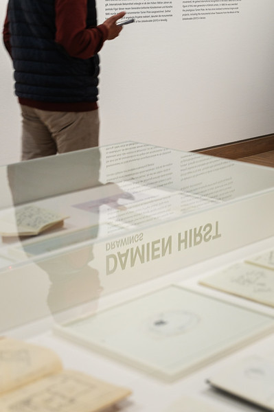 <p><a href="https://galleries.seirer-photography.com">seirer-photography</a><br />Design Exhibition Display with Partially Obscured Text and Gallery Visitor</p><p><a href="https://galleries.seirer-photography.com/Events/2025/2025-05-19-Damien-Hirst-Drawings-Albertina-Modern/i-j53H5Pt" title="Design Exhibition Display with Partially Obscured Text and Gallery Visitor"><img src="https://galleries.seirer-photography.com/Events/2025/2025-05-19-Damien-Hirst-Drawings-Albertina-Modern/i-j53H5Pt/0/LNHvNR5mVXbCd3sXbJsGDZQ86D2qzzQxhcDQQRqrT/Th/20250519_180903_albertina_hirst_8078-Th.jpg" width="150" height="150" alt="Design Exhibition Display with Partially Obscured Text and Gallery Visitor" title="Design Exhibition Display with Partially Obscured Text and Gallery Visitor" style="border: 1px solid #000000;" /></a></p>